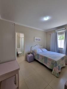 1 dormitorio con cama, aseo y ventana en Apartamentos próximo à praia, en Bombinhas