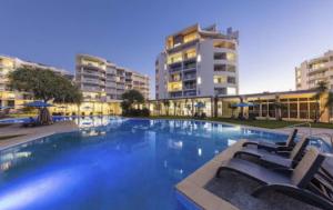 a large swimming pool with chairs and buildings at Marcoola Surf Air Hotel Room 2515 in Marcoola