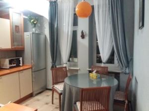 y cocina con mesa, sillas y nevera. en Apartment u Lidii in center of Kiev near railways station en Kiev