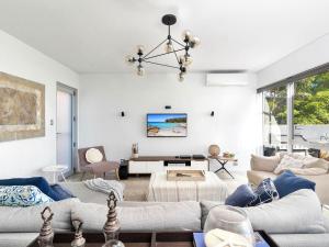 Sala de estar con 2 sofás y mesa en Rigel by Experience Jervis Bay, en Vincentia