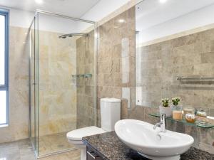 a bathroom with a toilet and a glass shower at Rigel by Experience Jervis Bay in Vincentia +23 photos