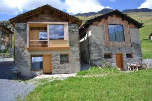 a stone house with a balcony on the side of it at Gääschi Leis in Vals
