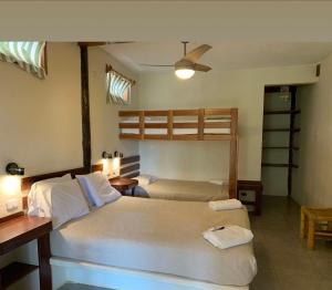 two beds in a room with two bunk beds at Hospedaje La Quebrada in Máncora