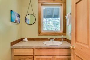 a bathroom with a sink and a window at Hot Tub Cool Views: Roaring Creek Cabin in Leavenworth +46 photos