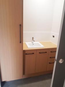 a bathroom with a sink and a wooden cabinet at Normanville Getaway in Normanville