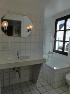 Un baño con lavabo, bañera e inodoro. en Hotel zur Post Dabringhausen, en Wermelskirchen 27 fotos más