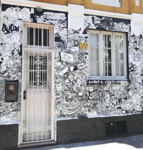 a building covered in graffiti with a door and windows at Tao Station 752 in Porto Alegre