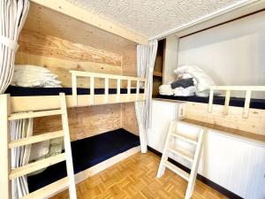 a room with two bunk beds and a ladder at ヴィラYukara緑屋 in Nanae