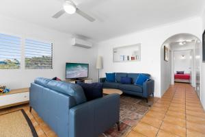 sala de estar con 2 sofás azules en Bayviews at Bongaree en Bongaree