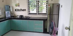a kitchen with a refrigerator and a fan at Sunrise Homestay in Alor Setar