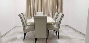 a white table and chairs in a dining room at Sunrise Homestay in Alor Setar +7 photos
