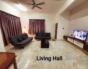 a living room with a couch and a tv at Sunrise Homestay in Alor Setar