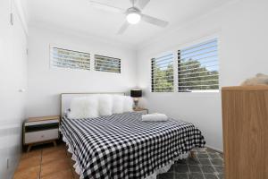 een slaapkamer met een bed met een zwart-witte deken bij Bayviews at Bongaree in Bongaree
