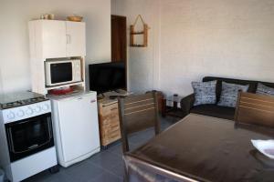 a small kitchen with a refrigerator and a microwave at La cabaña 5y15 in Playa Hermosa