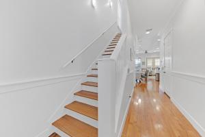 - un escalier blanc dans une maison dotée de murs blancs et de parquet dans l'établissement Gulf Blue Haven of Grayton Beach, à Santa Rosa Beach