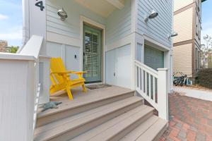une chaise jaune assise sur la terrasse couverte d'une maison dans l'établissement Gulf Blue Haven of Grayton Beach, à Santa Rosa Beach