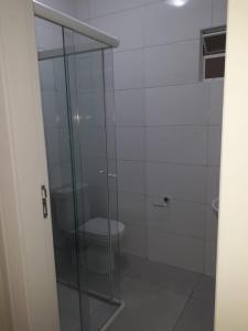 ein Badezimmer mit Glasdusche und Toilette in der Unterkunft Praia do Sonho in Palhoça + 14 Fotos