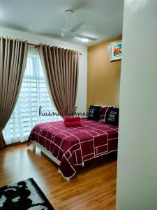a bedroom with a bed with a red blanket at Husna Apartment DPerdana Kota Bharu in Kota Bharu