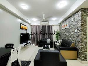 a living room with couches and a tv and a brick wall at Husna Apartment DPerdana Kota Bharu in Kota Bharu