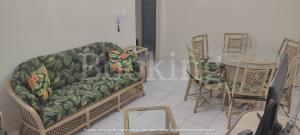 a living room with a couch and a glass table at Apartamento Praia da Enseada in Guarujá