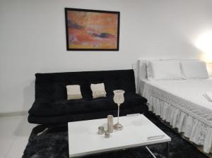 sala de estar con sofá negro y mesa en Tuareg Suite Deluxe, en Santa Cruz de la Sierra