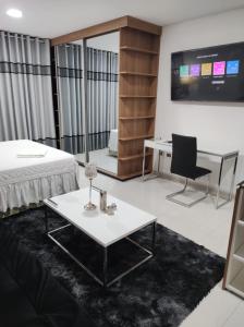 Una habitación con una cama, una mesa y un televisor. en Tuareg Suite Deluxe, en Santa Cruz de la Sierra