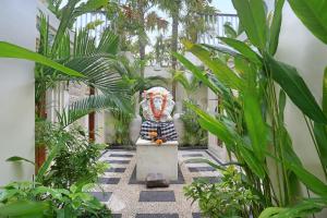 a statue in the middle of a courtyard with plants at The Wina Villa Canggu in Canggu