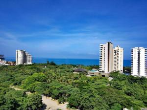 une vue aérienne sur une ville avec de grands bâtiments et des arbres dans l'établissement Pozos colorado Bello horizonte - Apartamento 70 mt2, à Santa Marta