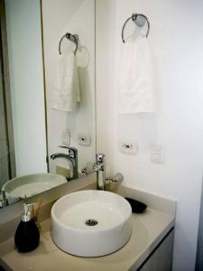a white bathroom with a sink and a mirror at Pozos colorado Bello horizonte - Apartamento 70 mt2 in Santa Marta