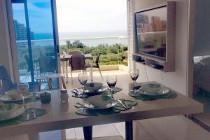 una mesa con copas de vino y platos en ella en Pozos colorado Bello horizonte - Apartamento 70 mt2, en Santa Marta