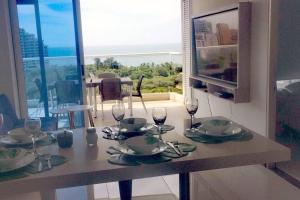 a table with wine glasses and plates on it at Pozos colorado Bello horizonte - Apartamento 70 mt2 in Santa Marta