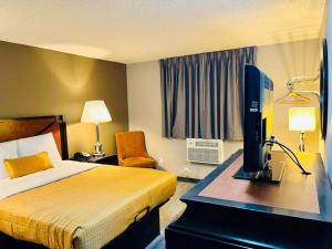 a hotel room with a bed and a computer on a desk at Super 8 by Wyndham Benton Harbor St Joseph in Benton Harbor