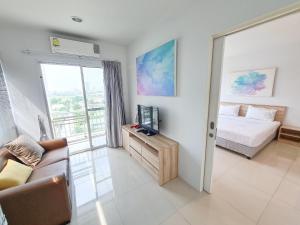 ein Wohnzimmer mit einem Bett und einer Couch in der Unterkunft Des Res Hotel and Residence in Bangna