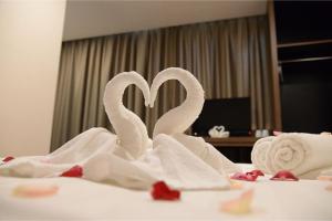 zwei Schwäne aus Handtüchern auf einem Bett in der Unterkunft MII Smile Hotel Penang in George Town