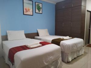 a hotel room with two beds with towels on them at โสดาอพาร์ทเม้นท์​ in Ban Lam Phak Kut