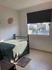a bedroom with a bed and a window at Acapulco Marina diamante departamento con alberca y club náutico in Acapulco