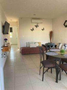 阿卡普尔科Acapulco Marina diamante departamento con alberca y club náutico的客厅里有一张桌子和一张沙发 更多15张照片