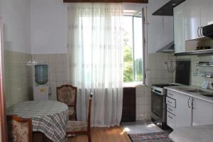 a small kitchen with a table and a window at Guest House Niako in Makhinjauri