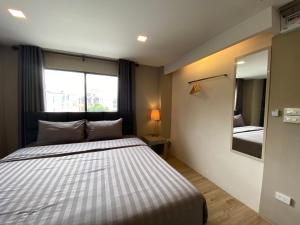 a bedroom with a bed and a large window at Bansuay Bangkadi in Pathum Thani