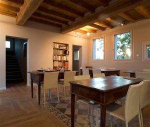 a dining room with wooden tables and white chairs at Agriturismo Il Cielo di Strela in Compiano