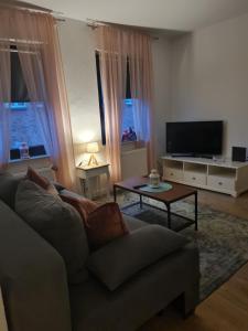 uma sala de estar com um sofá e uma televisão em SECOND HOME bitte beachten Sie den Check in und Check out em Neuss