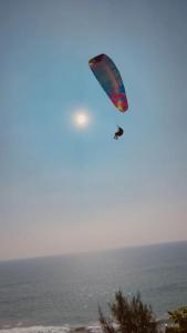 a person is flying a kite over the ocean at Sand castle varkala in Varkala