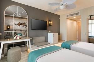 Cette chambre comprend un lit et une télévision. dans l'établissement Limak Arcadia Sport Resort Belek, à Belek