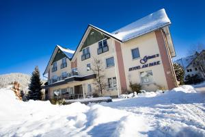 ein Gebäude mit Schnee davor in der Unterkunft Göbel's Gästehaus Hotel am Park in Willingen
