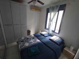 una camera da letto con un letto blu e una finestra di Charmant appt proche de toutes commodités a La Possession