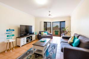 a living room with two couches and a tv at Breakers 1 3 LJHooker Yamba in Yamba