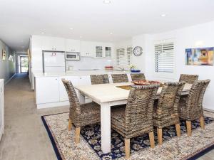 a kitchen with a wooden table and chairs at Aroona at Minnamurra in Minnamurra