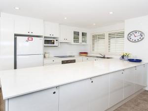 a kitchen with white cabinets and a white counter top at Aroona at Minnamurra in Minnamurra