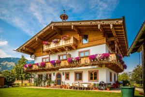 una casa con balcón y flores. en Ferienwohnung Hansenbauer, en Saalfelden am Steinernen Meer