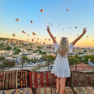 a little girl standing on a couch watching hot air balloons at Hera Cave Suites in Göreme